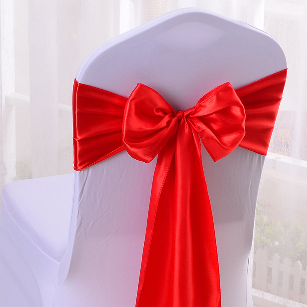 Satin silk chair sash in assorted colors tied around a white folding event chair