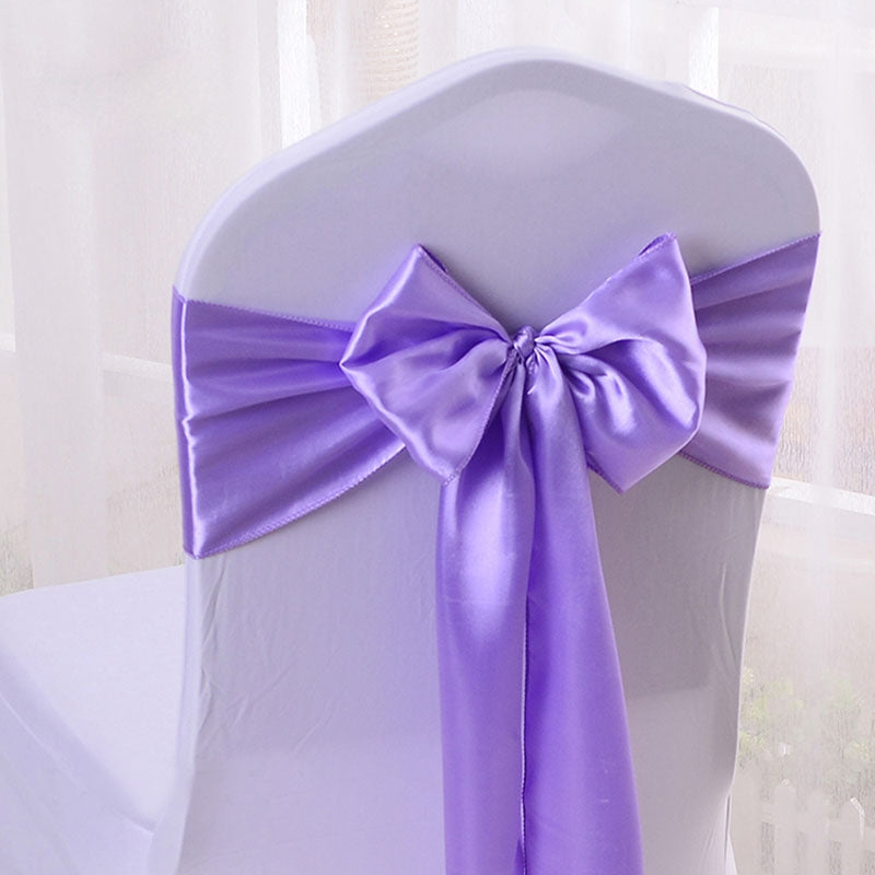 Satin silk chair sash in assorted colors tied around a white folding event chair